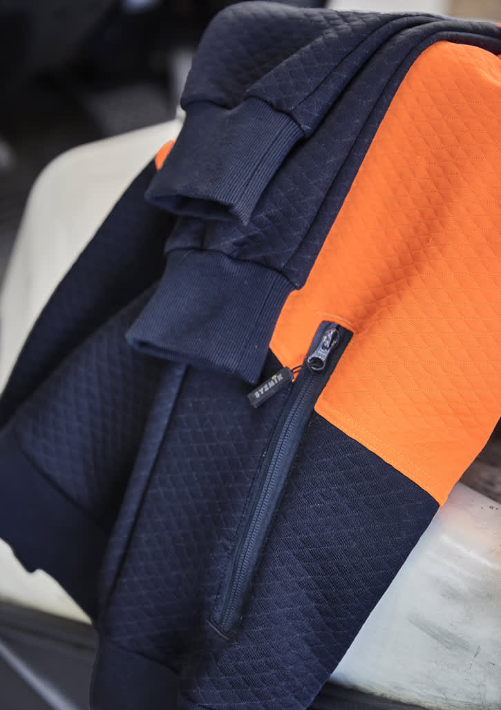 A textured jacquard hoodie featuring navy and orange colours, with a front zip pocket and a logo.