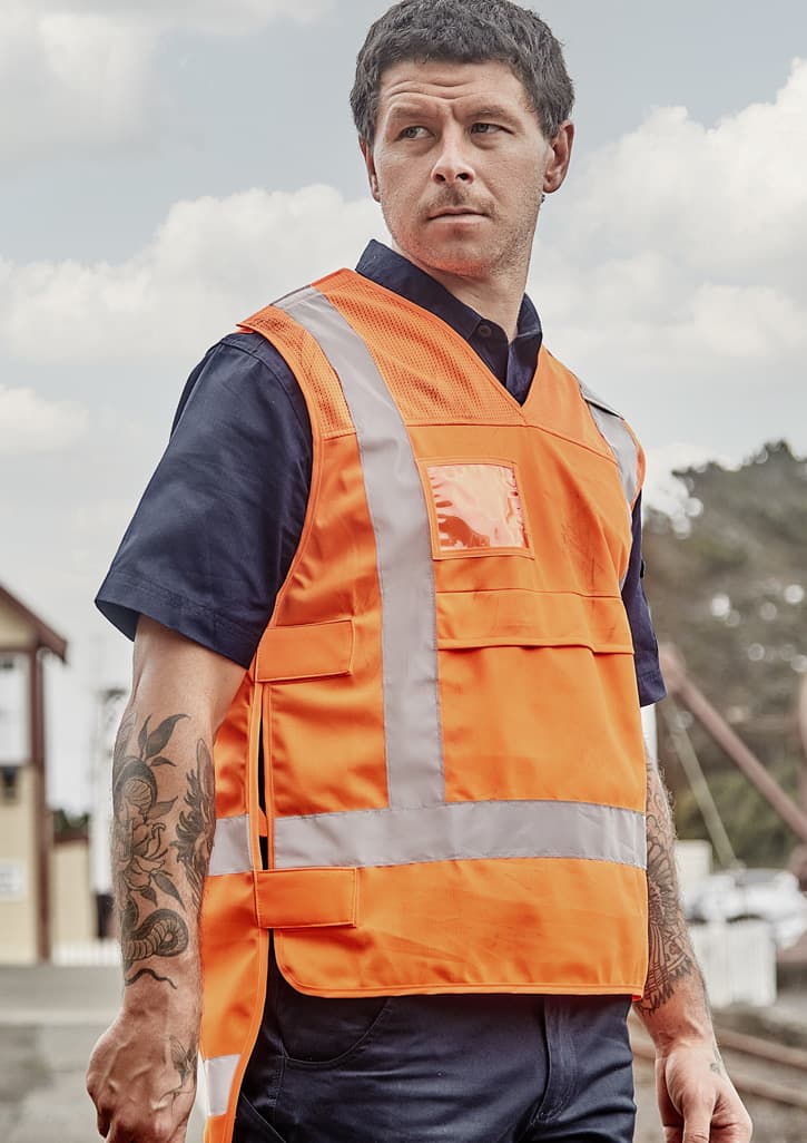 A unisex hi-vis safety vest in bright orange, featuring reflective strips and pockets, shown on a model.