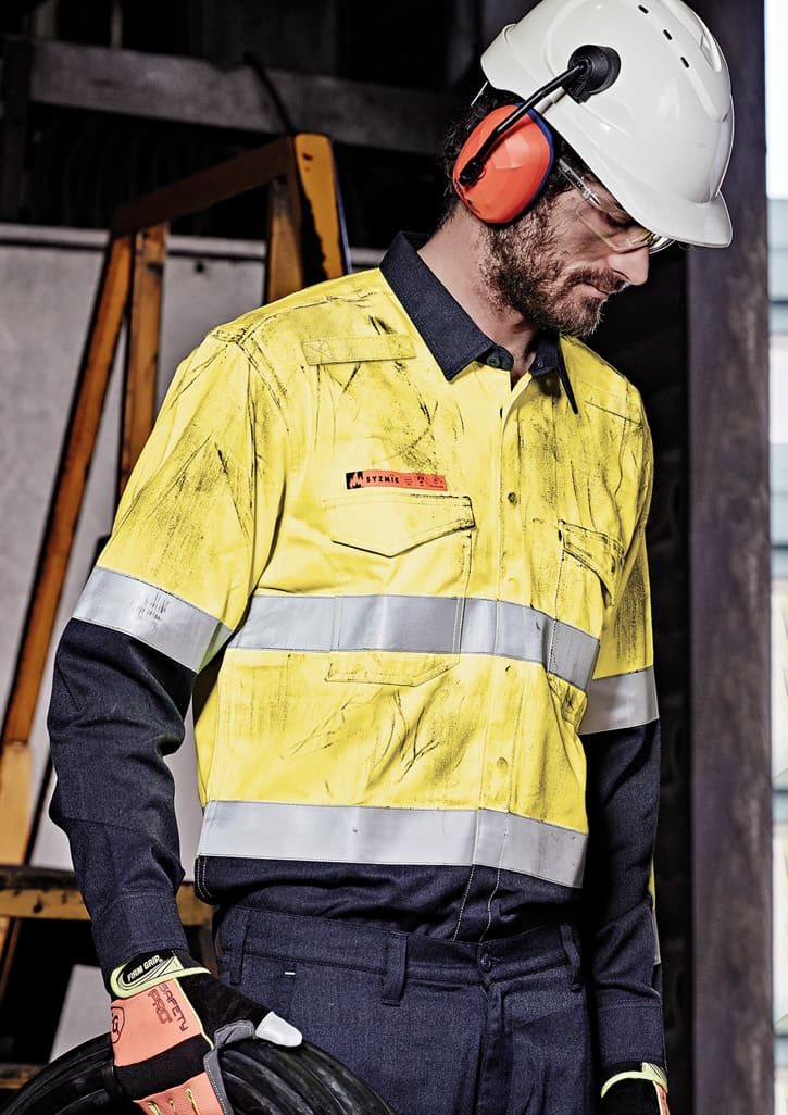 A high visibility yellow and navy work shirt with hoop tape detailing, worn by a man in safety gear.