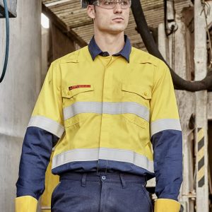 A man in a yellow and navy spliced work shirt with reflective stripes, wearing a hard hat and safety glasses.