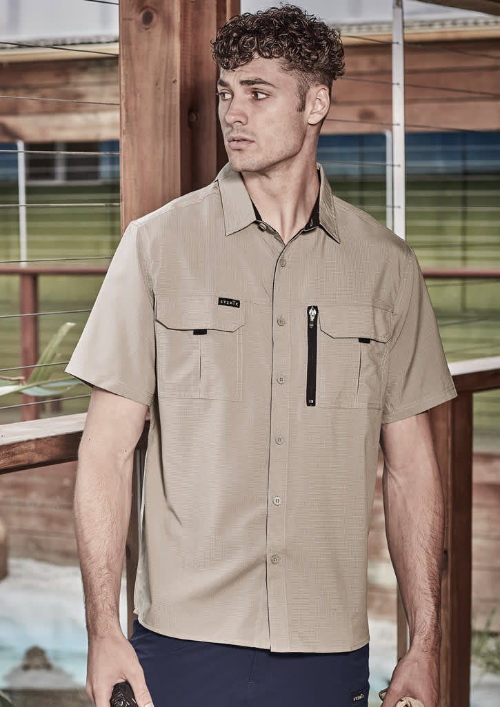 A light beige men's short sleeve button-up shirt with two chest pockets and a zipper pocket, featuring a logo.