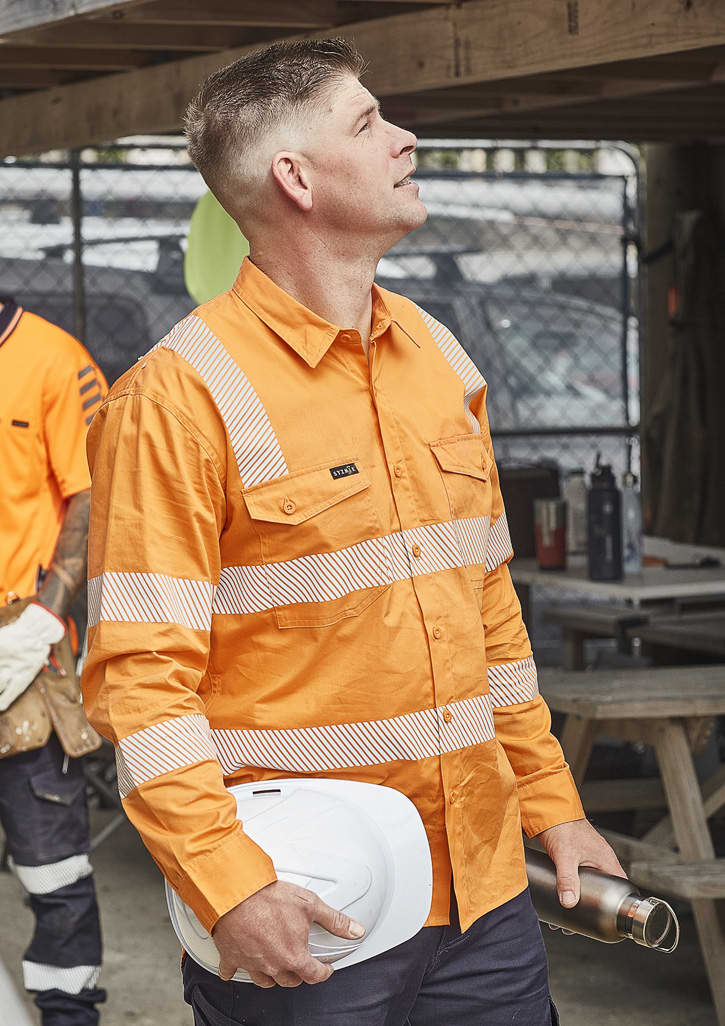 An orange long-sleeve work shirt with segmented reflective tape, featuring a pocket and a branding logo.