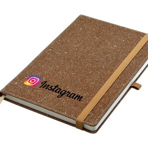 A brown A5 notebook with a textured cover and elastic band, featuring a logo on the front.
