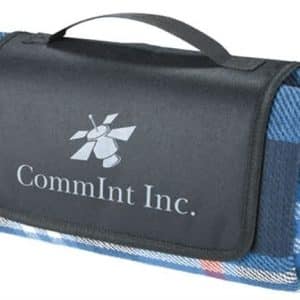 A folded blue picnic rug with a black carrying handle and a logo on the surface.