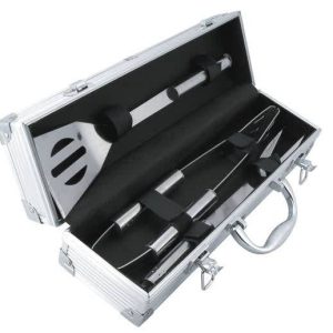 A BBQ set in a silver case, featuring a spatula, tongs, and a fork, with black accents.