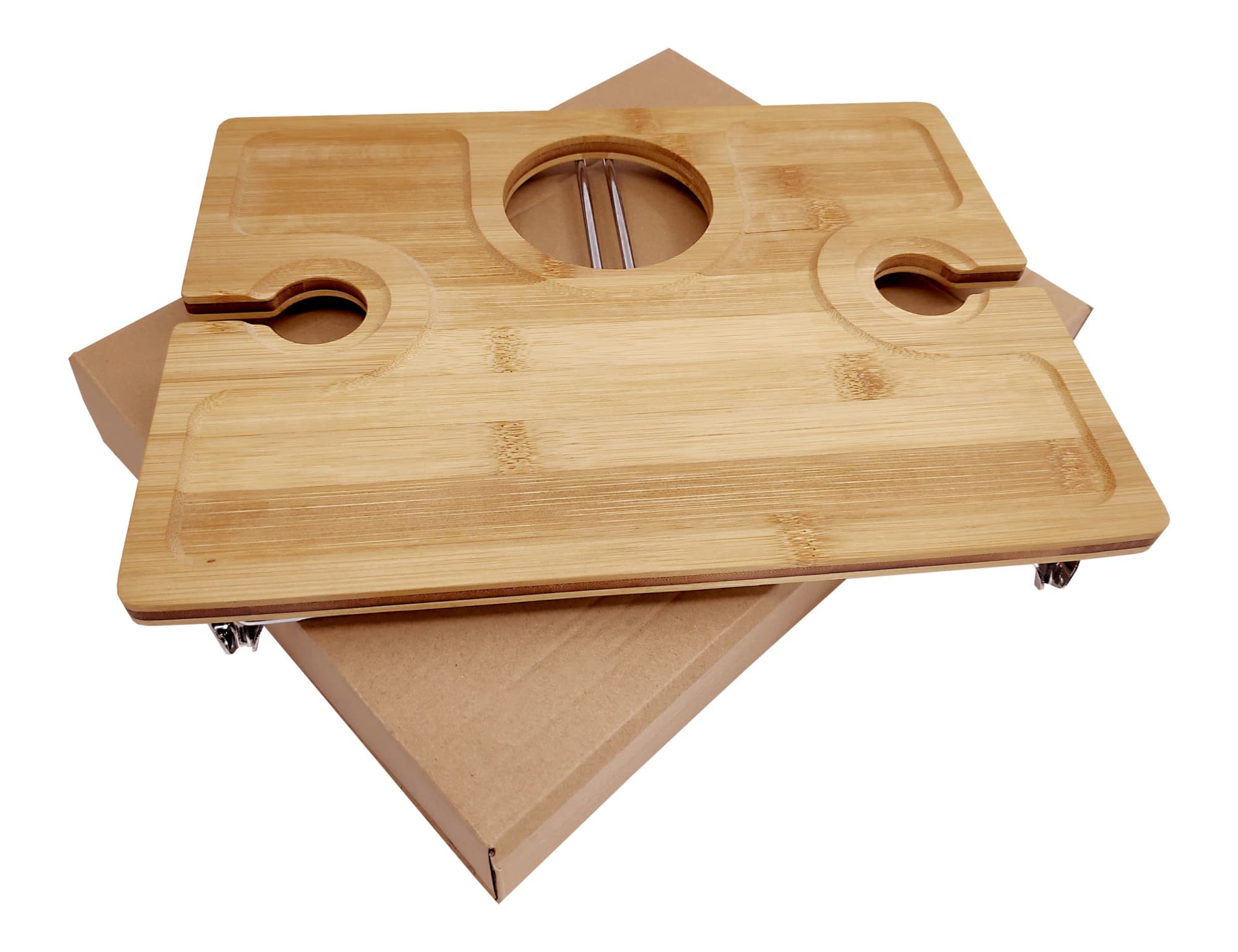 A bamboo picnic board with cutouts for glasses and a central hole, placed on a kraft paper box.