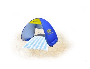A blue and grey pop-up beach shelter with a striped towel on sand, featuring a logo on one side.