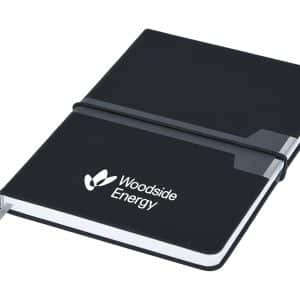 A black A5 notebook with a secure elastic band and a grey tab, featuring a logo on the cover.