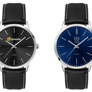 A men's dress watch with a black dial and silver hands, featuring a leather strap. Another watch has a blue dial.