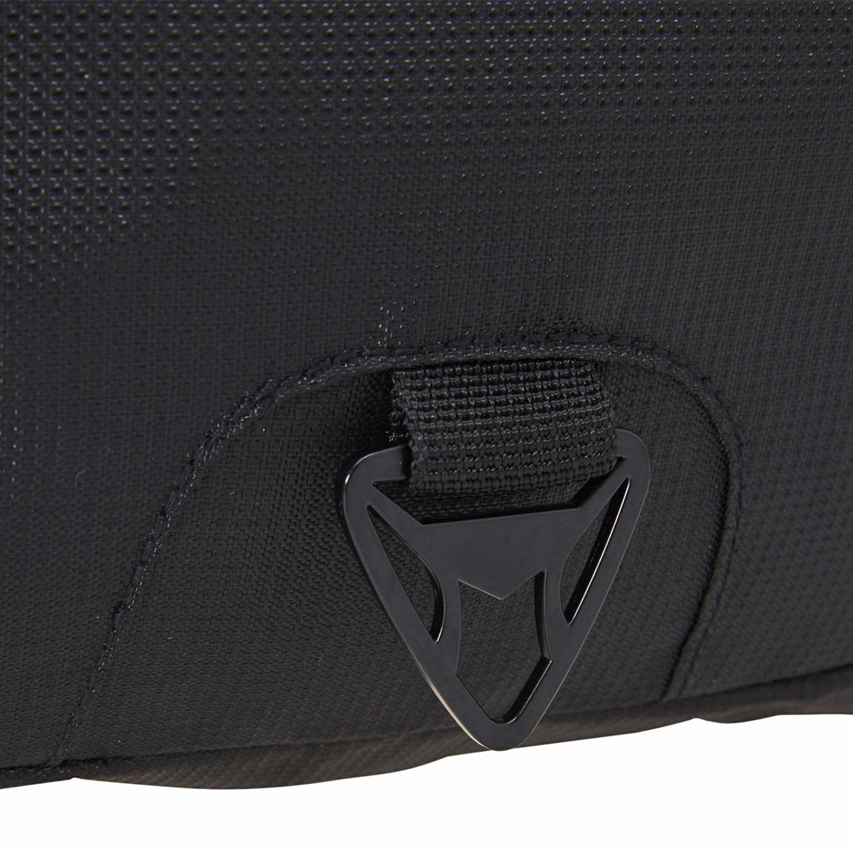 A close-up of a black fabric section of a laptop backpack featuring a logo and a buckle attachment.