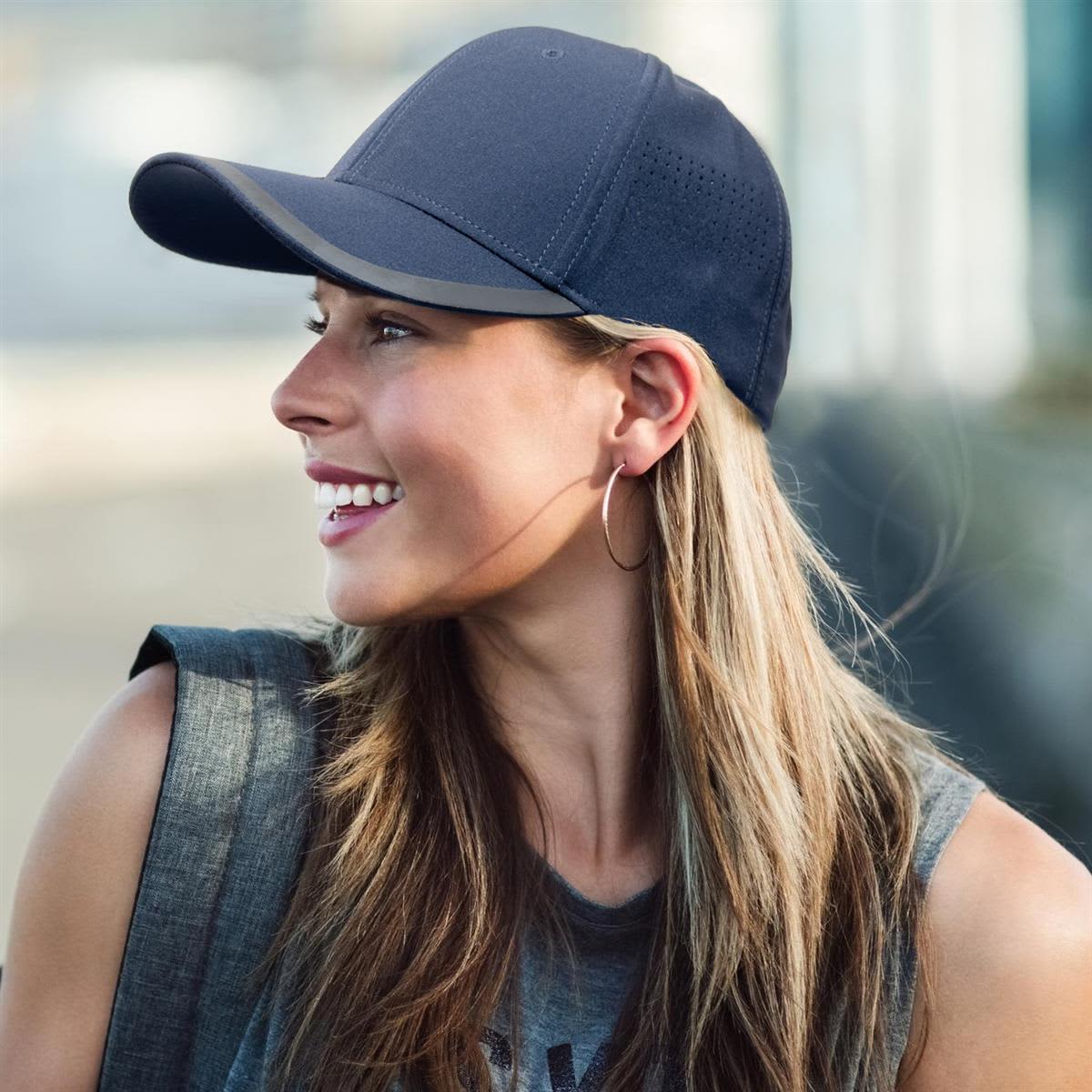 A navy cap with a curved brim, featuring a logo, worn by a smiling woman with long hair.