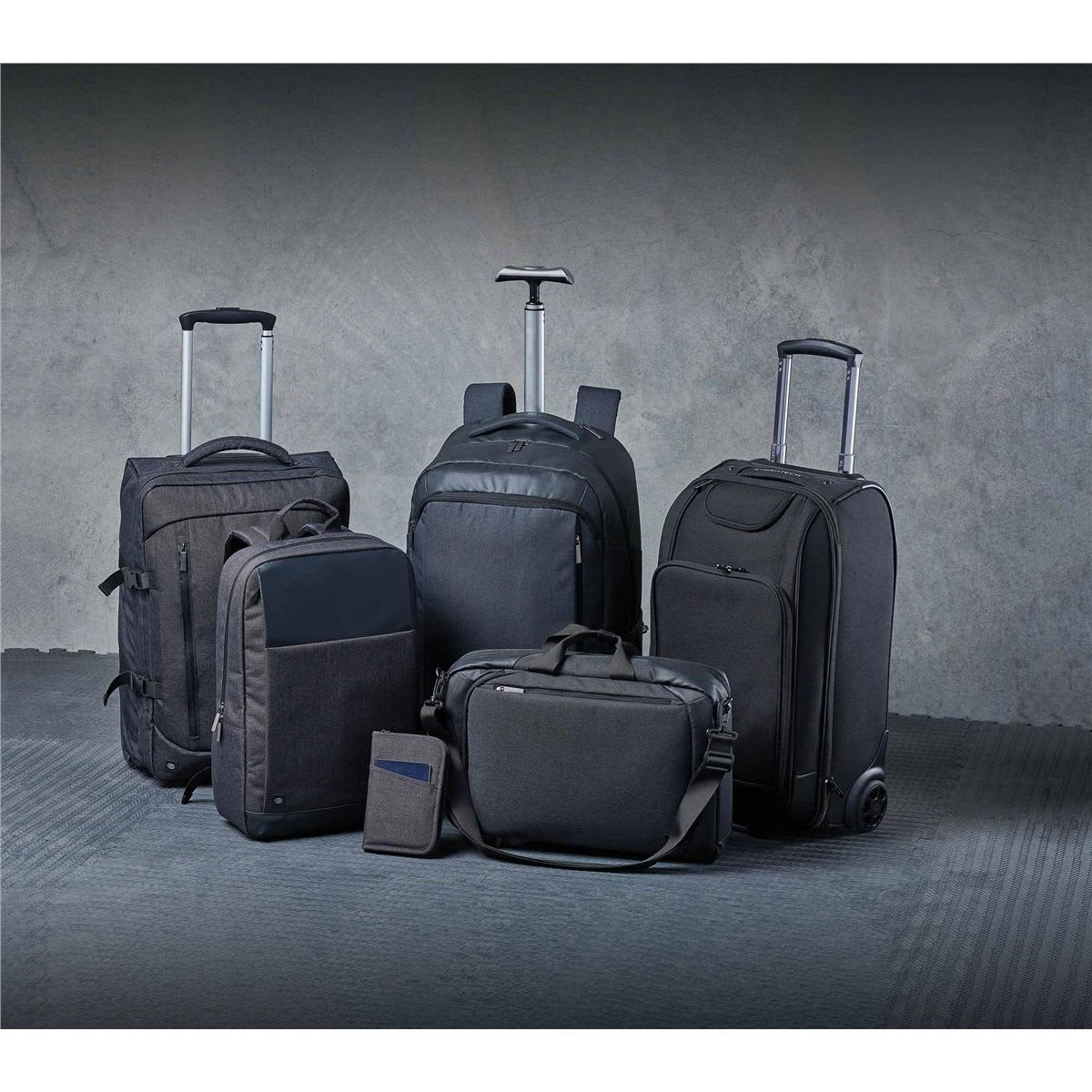 A collection of black bags, including backpacks, a wheeled suitcase, and a messenger bag, with a sleek design.