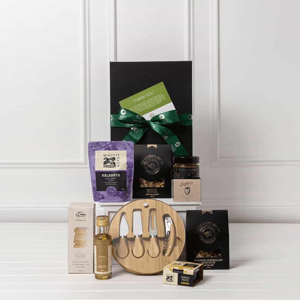 A gourmet gift pack featuring a wooden platter, condiments, oils, snacks, and a variety of packaging, all in black.
