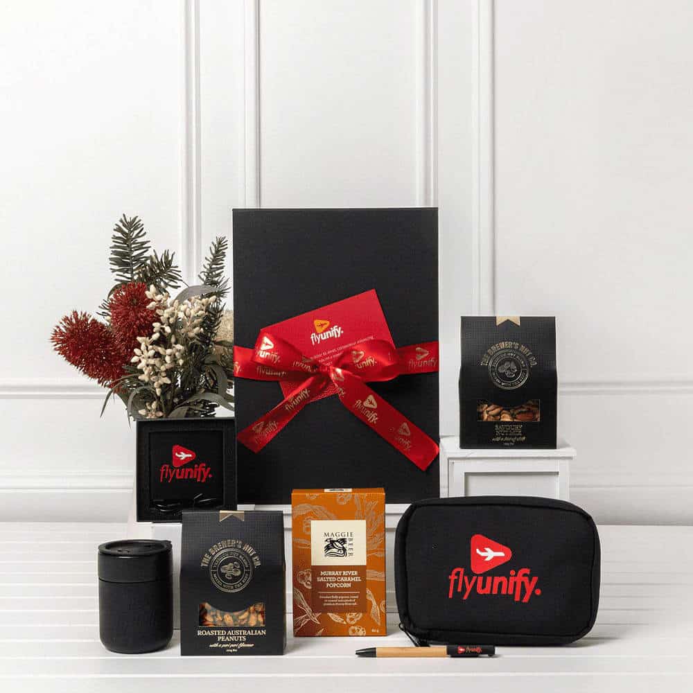 A black gift box tied with a red ribbon contains various items, including a drink bottle, a coffee pack, and a branded pouch.