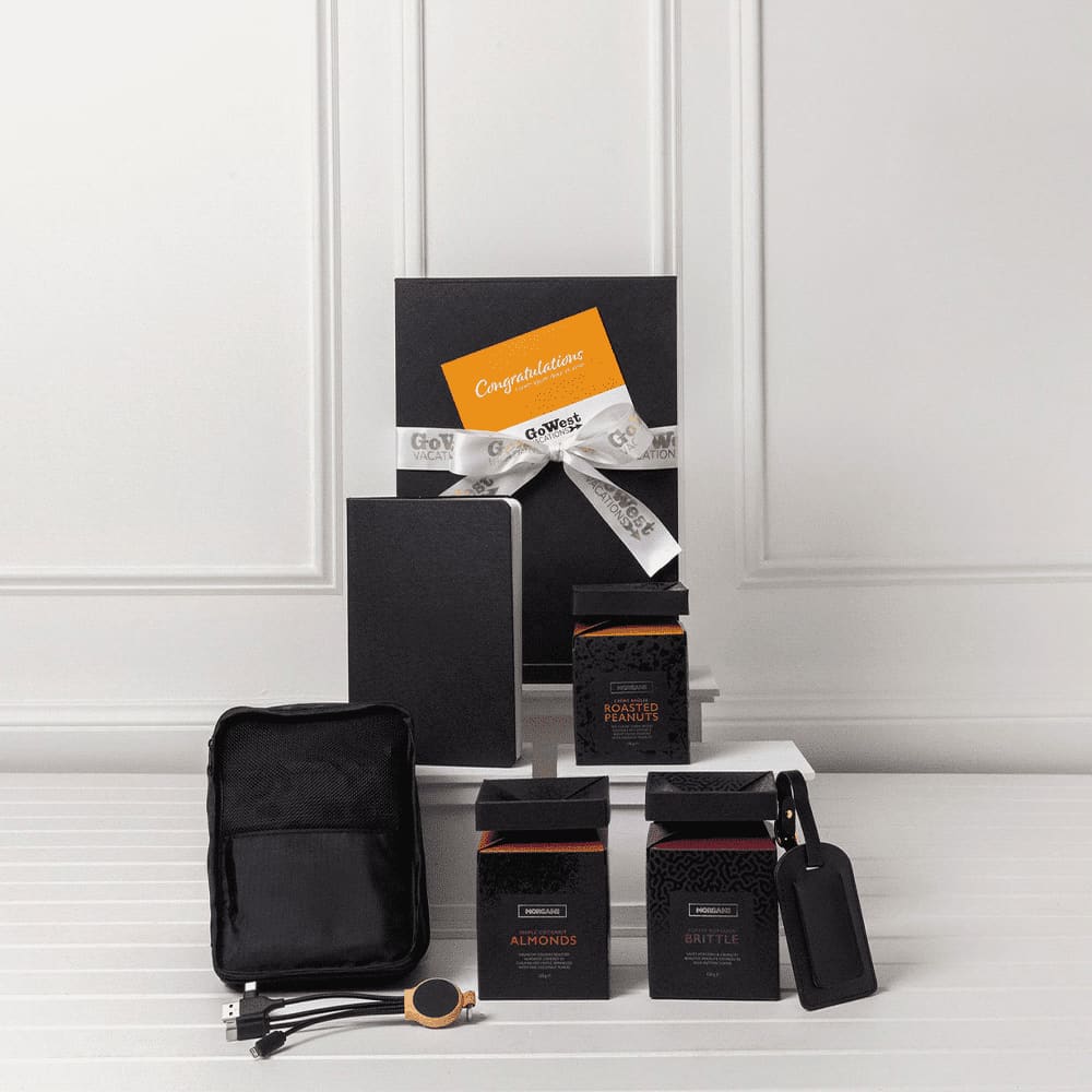 A travel kit featuring a notebook, two black boxes, a pouch, and a tag. All items are arranged on a white surface.