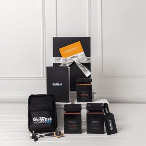 A travel kit featuring a black pouch, travel accessories, two boxes, and a notebook, all packaged in a stylish setup.