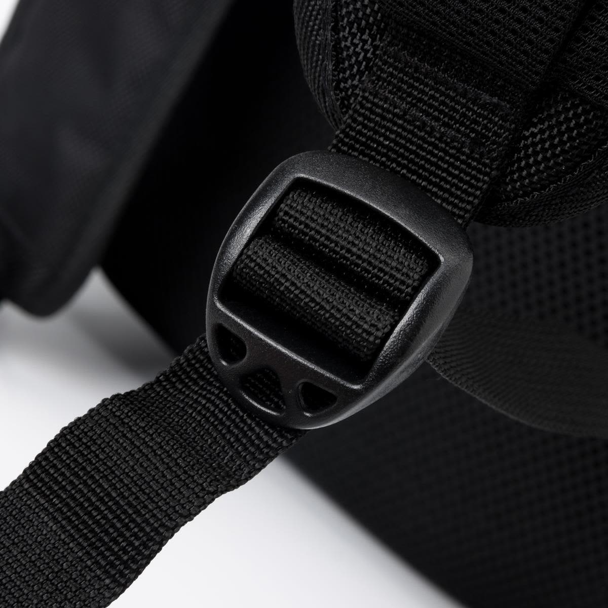 A close-up of a black backpack strap featuring an adjustable buckle and textured fabric.