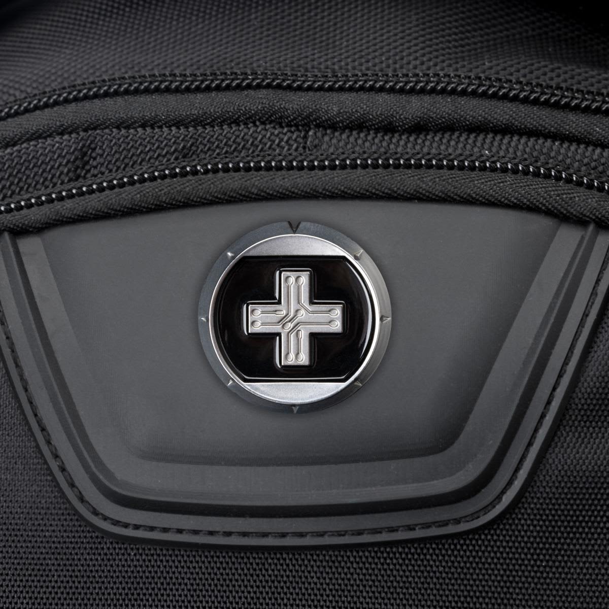A close-up of a black backpack featuring a round logo on a zippered pocket.