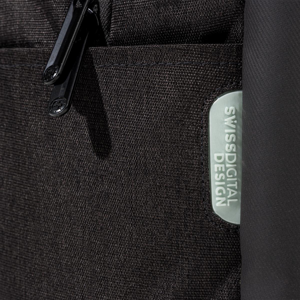 A close-up of a black backpack featuring a textured fabric and a logo patch.