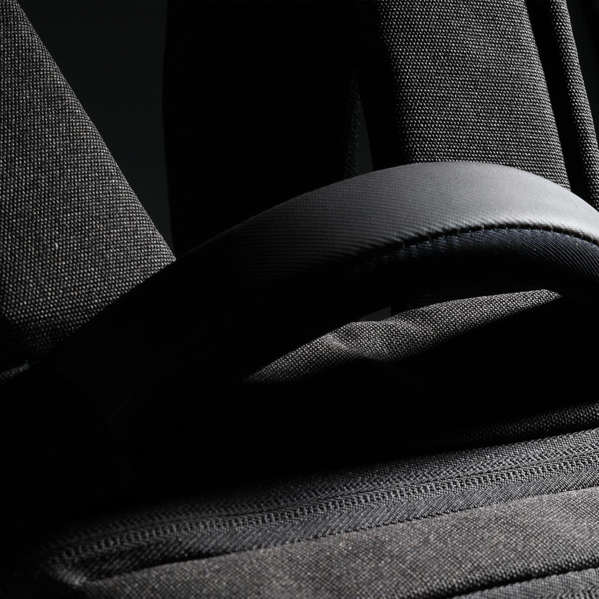 A black backpack featuring padded straps and textured fabric, with a small logo visible.