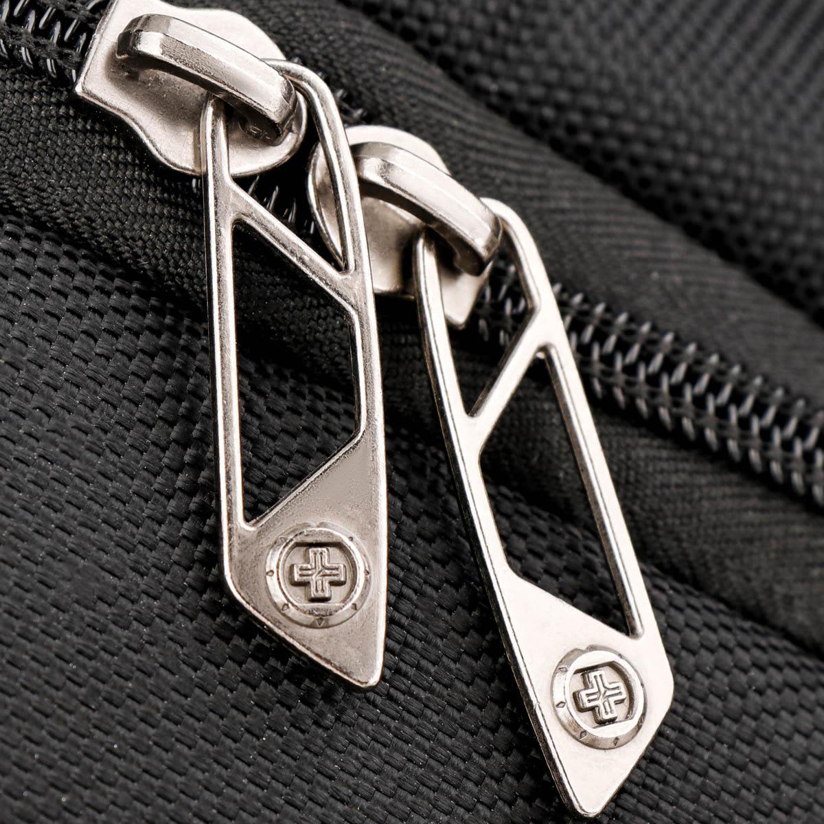 Close-up of silver zippers on a black backpack, featuring a branded logo on the zipper pulls.
