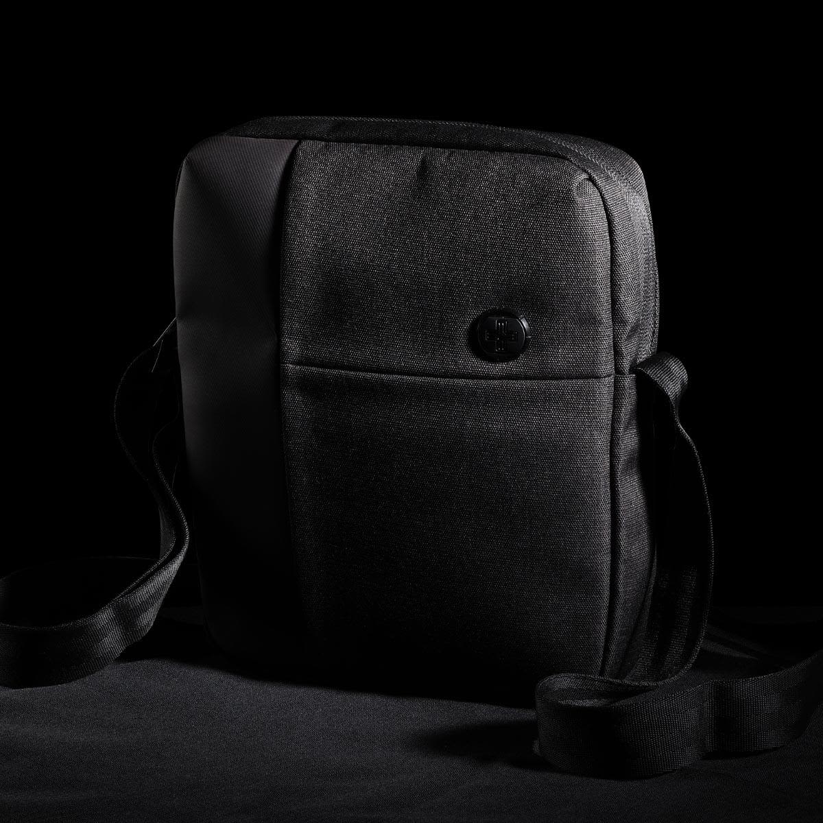 A black shoulder bag featuring a sleek design and a shoulder strap, with a button logo on the front.
