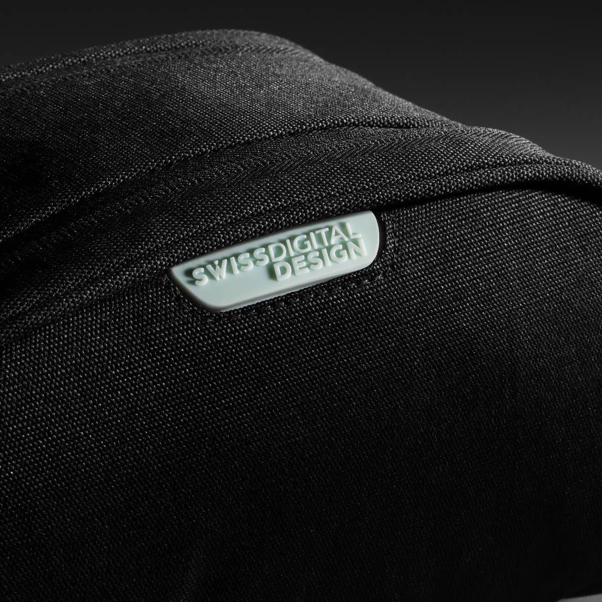 A black toiletry bag with a textured surface and a logo. The design is sleek and modern.