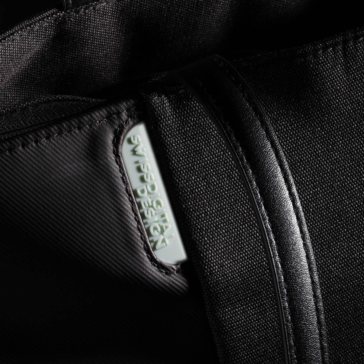 A black tote bag with a zipper and a prominent logo tag features a sleek, minimalist design.
