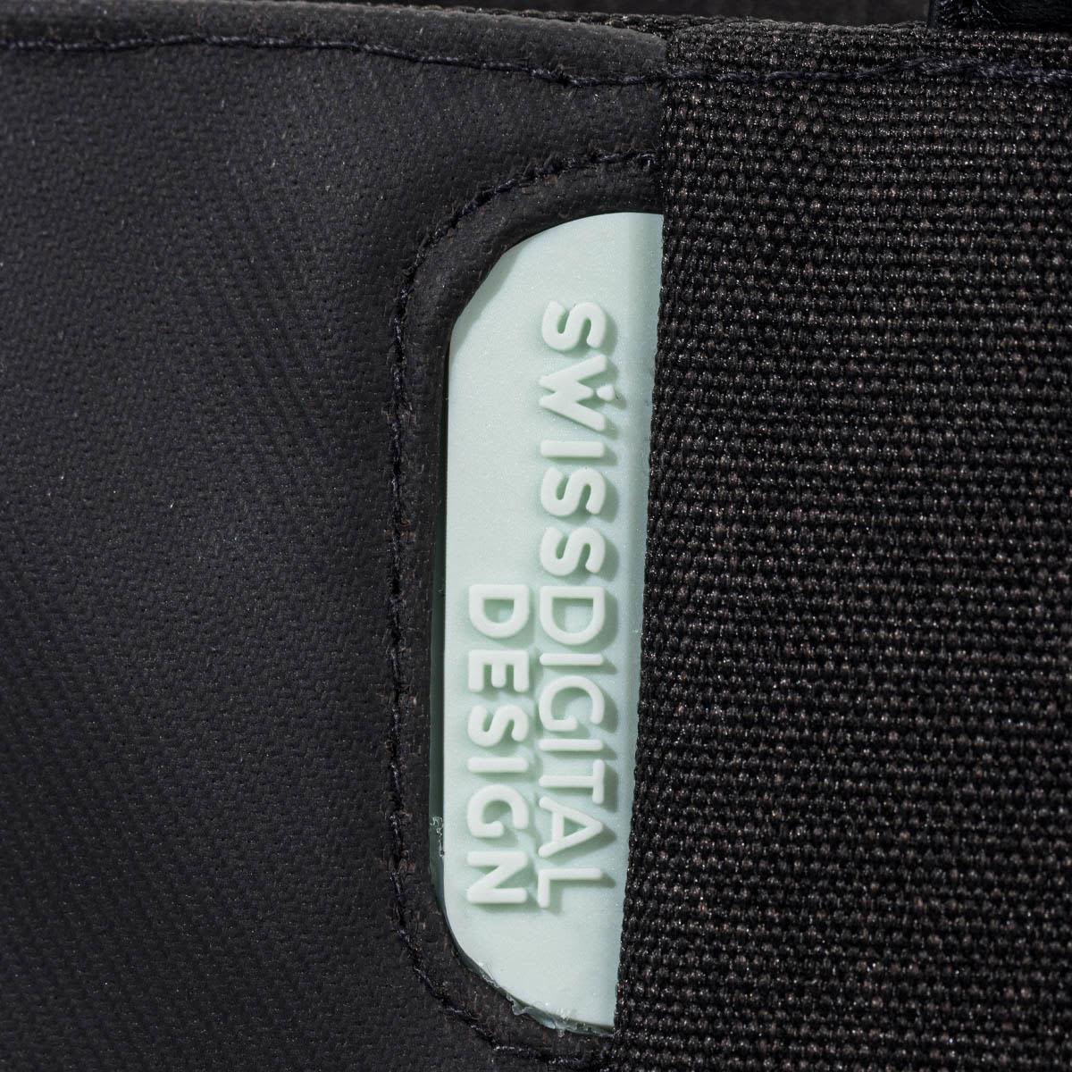 A black tote bag featuring a light blue branding label, made with a durable fabric.