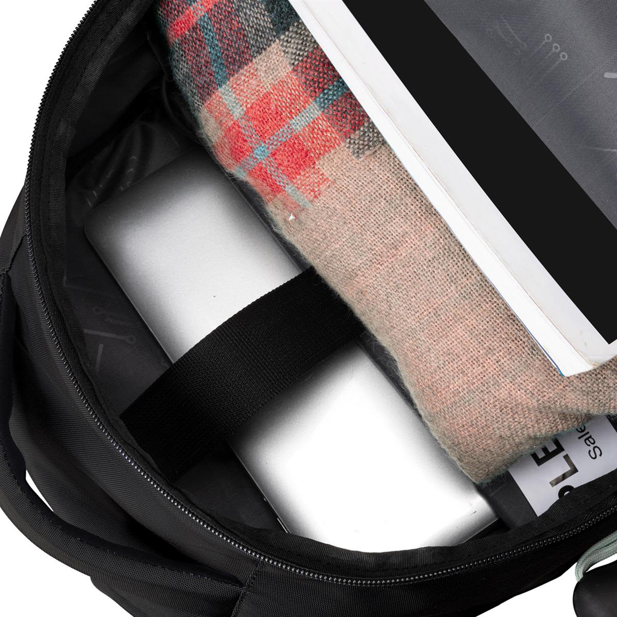 A black backpack interior displaying a laptop, a blanket, and a document. It features an inner logo.