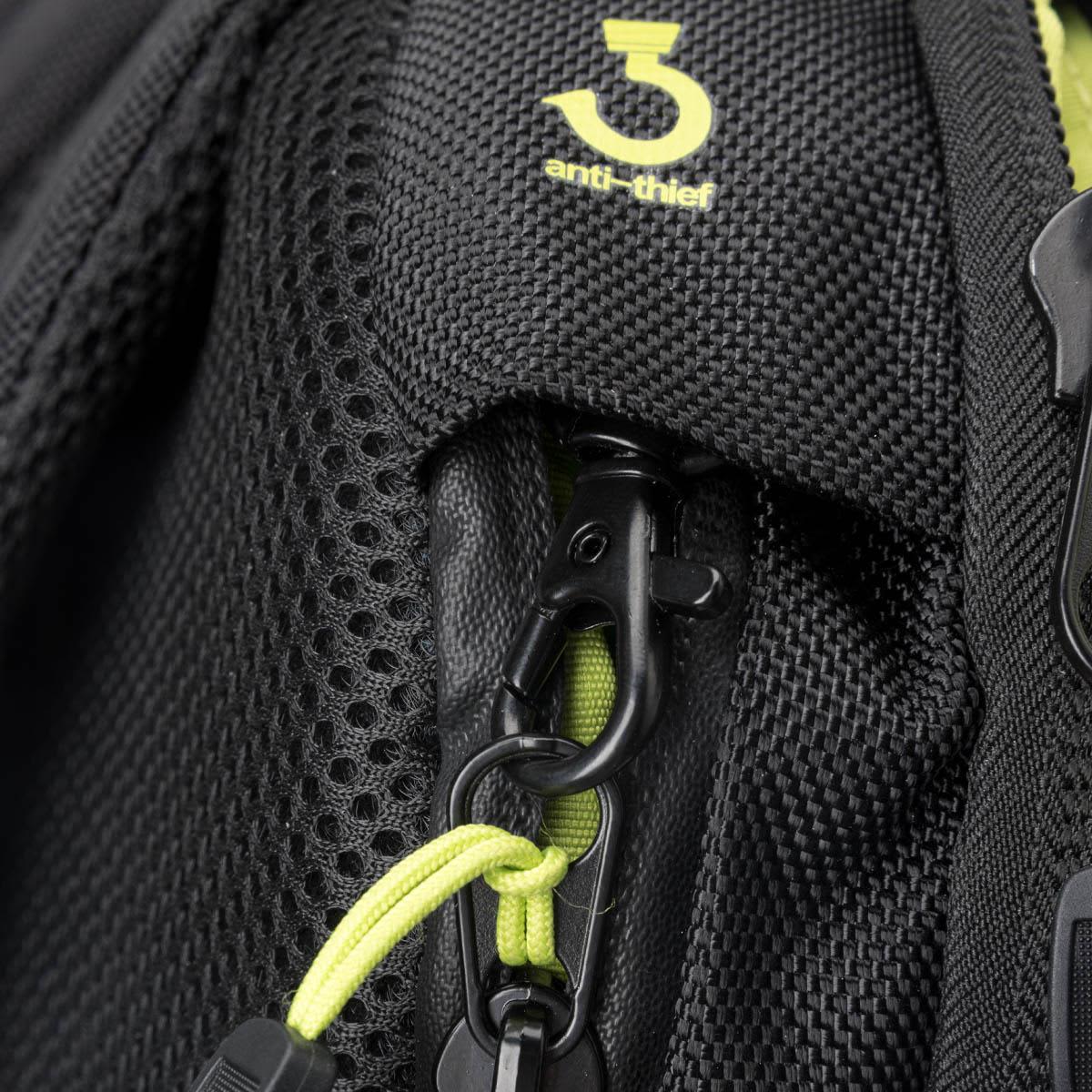 A close-up of a black backpack featuring a clip and anti-thief zipper with contrasting bright yellow accents.