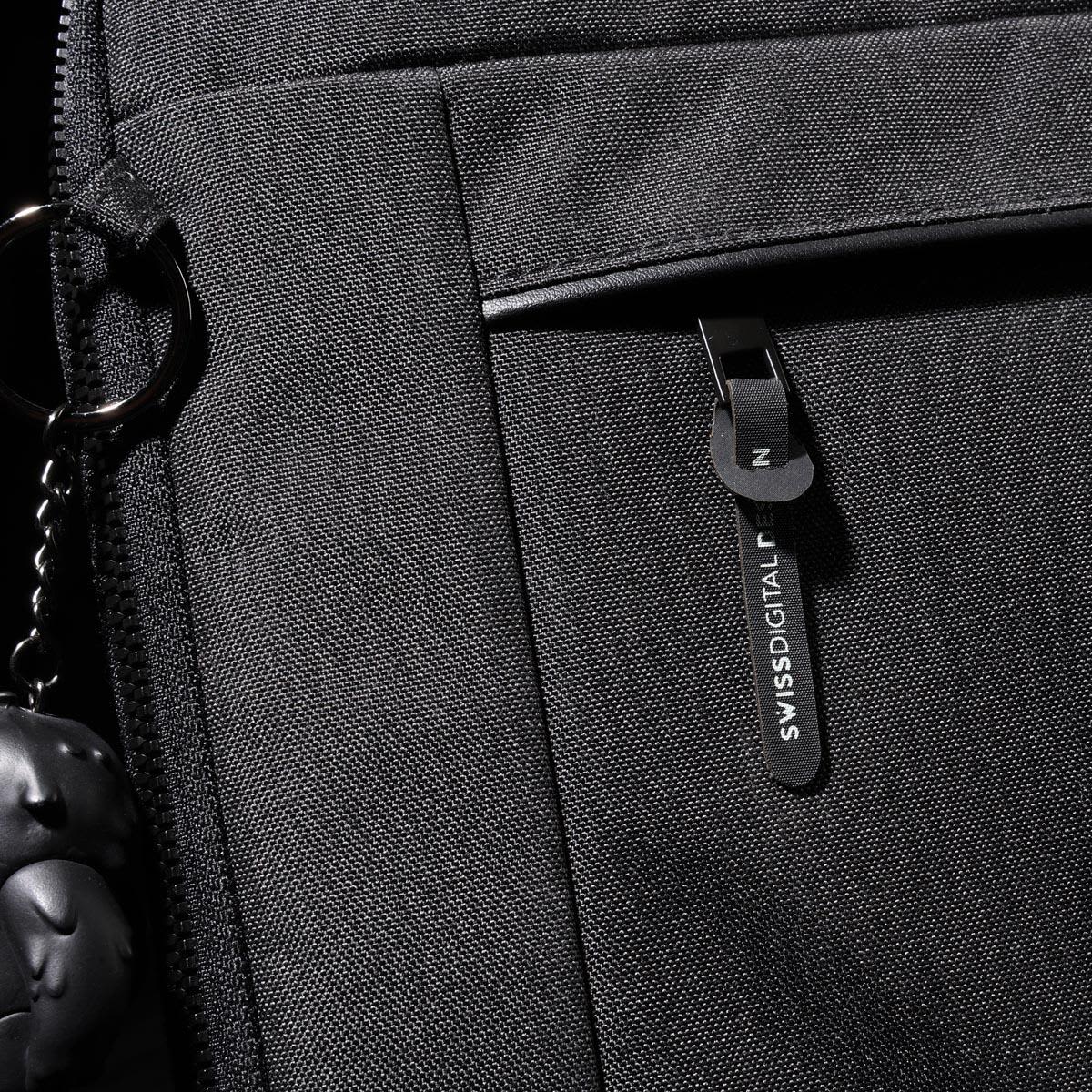 A black laptop sleeve with a zippered pocket and a branded tag. Features a keychain accessory attached.