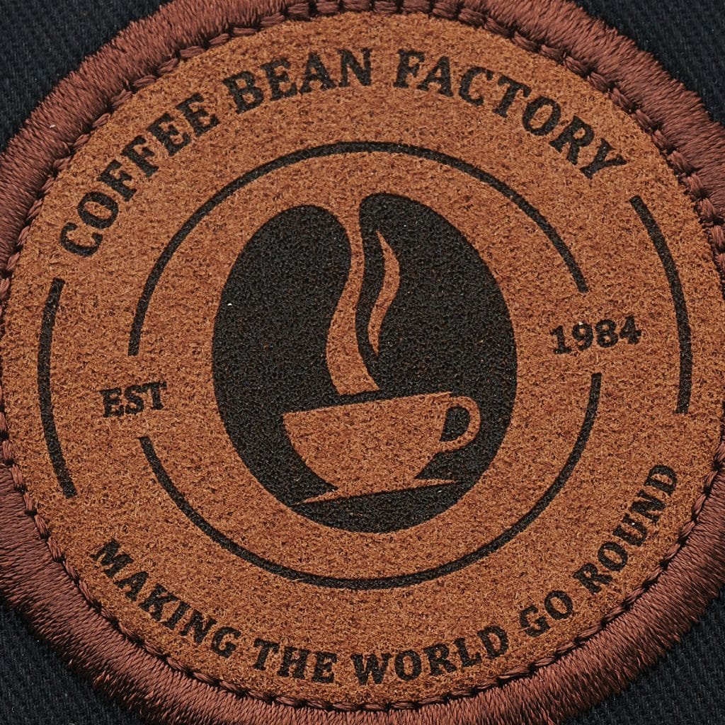 Brown circular SupaEtch patch with vintage coffee cup logo and "Making the World Go Round" tagline.