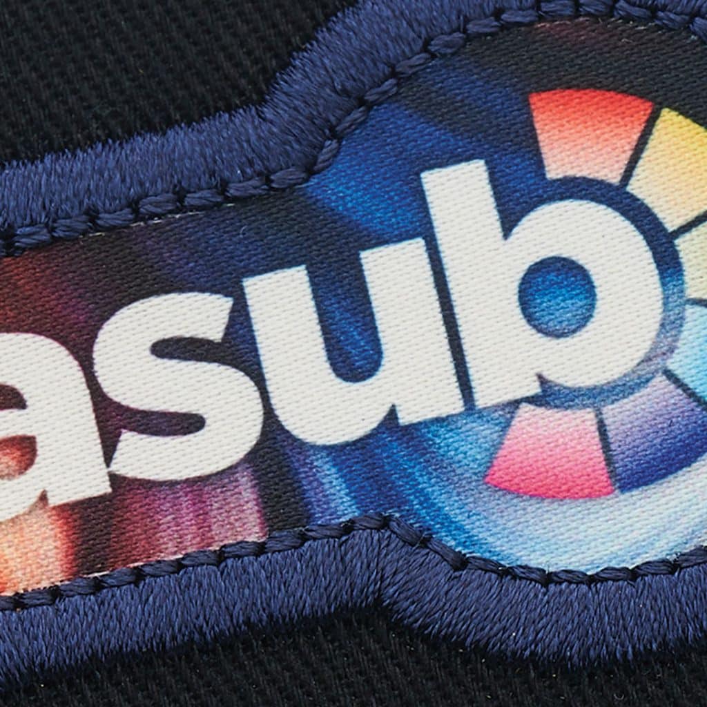 Close-up of a circular SupaSub patch with bold digital colour gradients and a blue orb, demonstrating high-definition best branded merchandise.