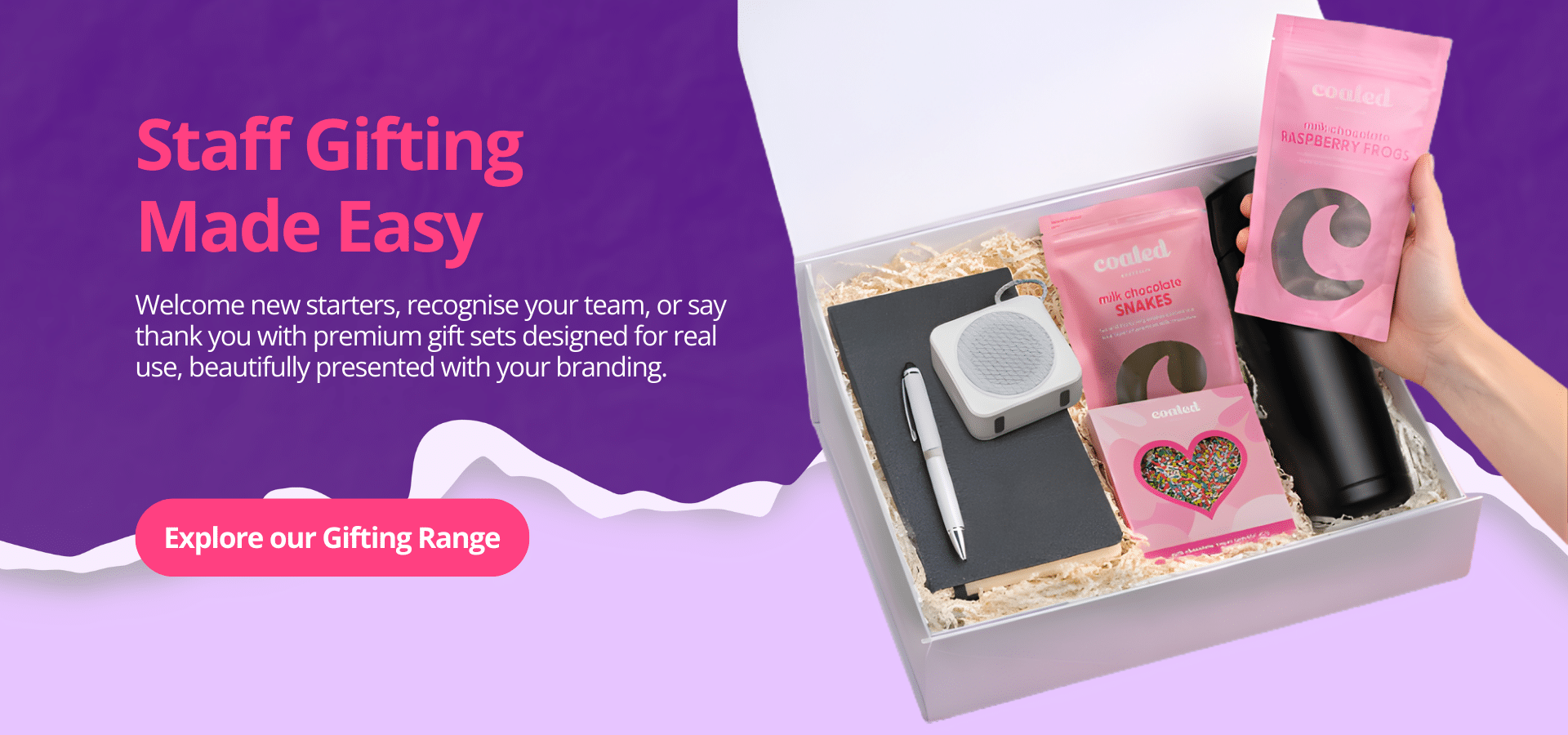 Staff gifting corporate gift box with branded drink bottle, notebook, pen, speaker and gourmet chocolates, promoting premium onboarding and employee gift sets.