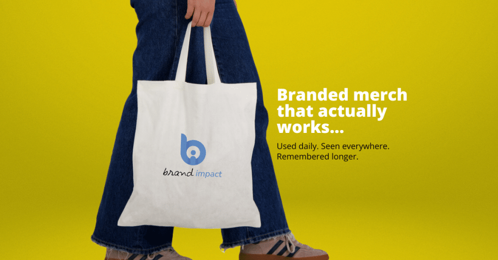 Person holding a branded tote bag with logo on a yellow background with text “Branded merch that actually works,” representing effective promotional products used daily.