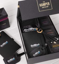 A custom travel kit featuring a black bag, snack packs, luggage tags, and a logo.