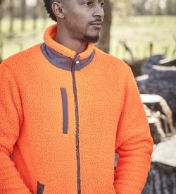 A man wearing an orange unisex full zip sherpa fleece, featuring a high collar and zippered front pockets.